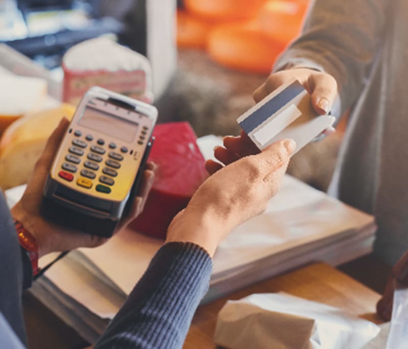 woman handing over credit card to cashier