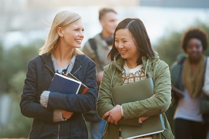 Shot of two student friends walking to class together