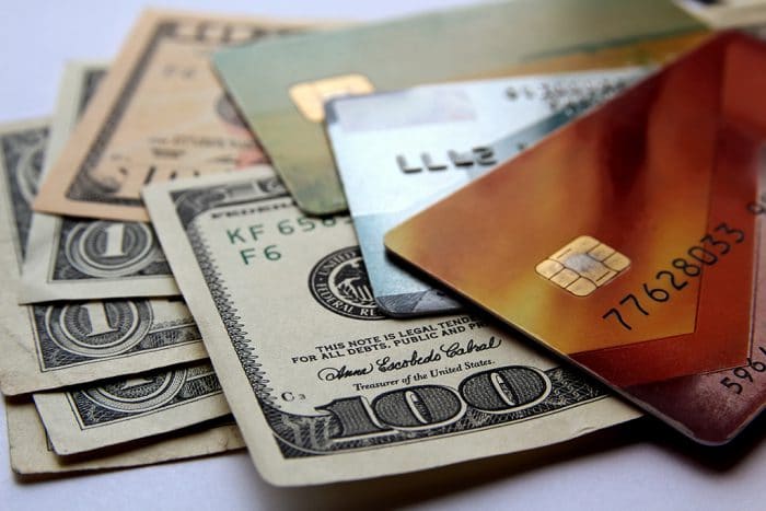 Stack of credit cards and american dollars, close-up view.