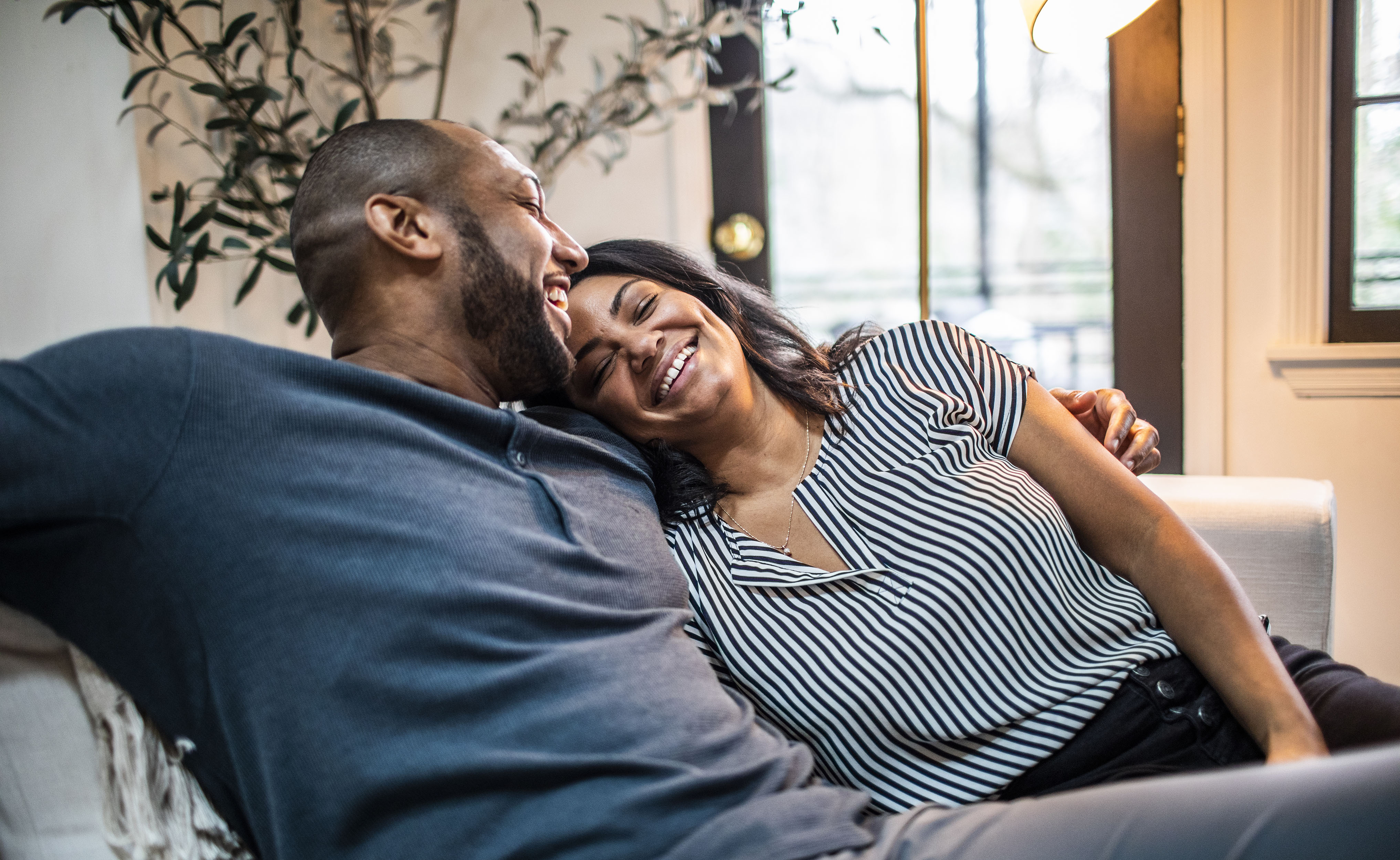 Married couple embracing on sofa