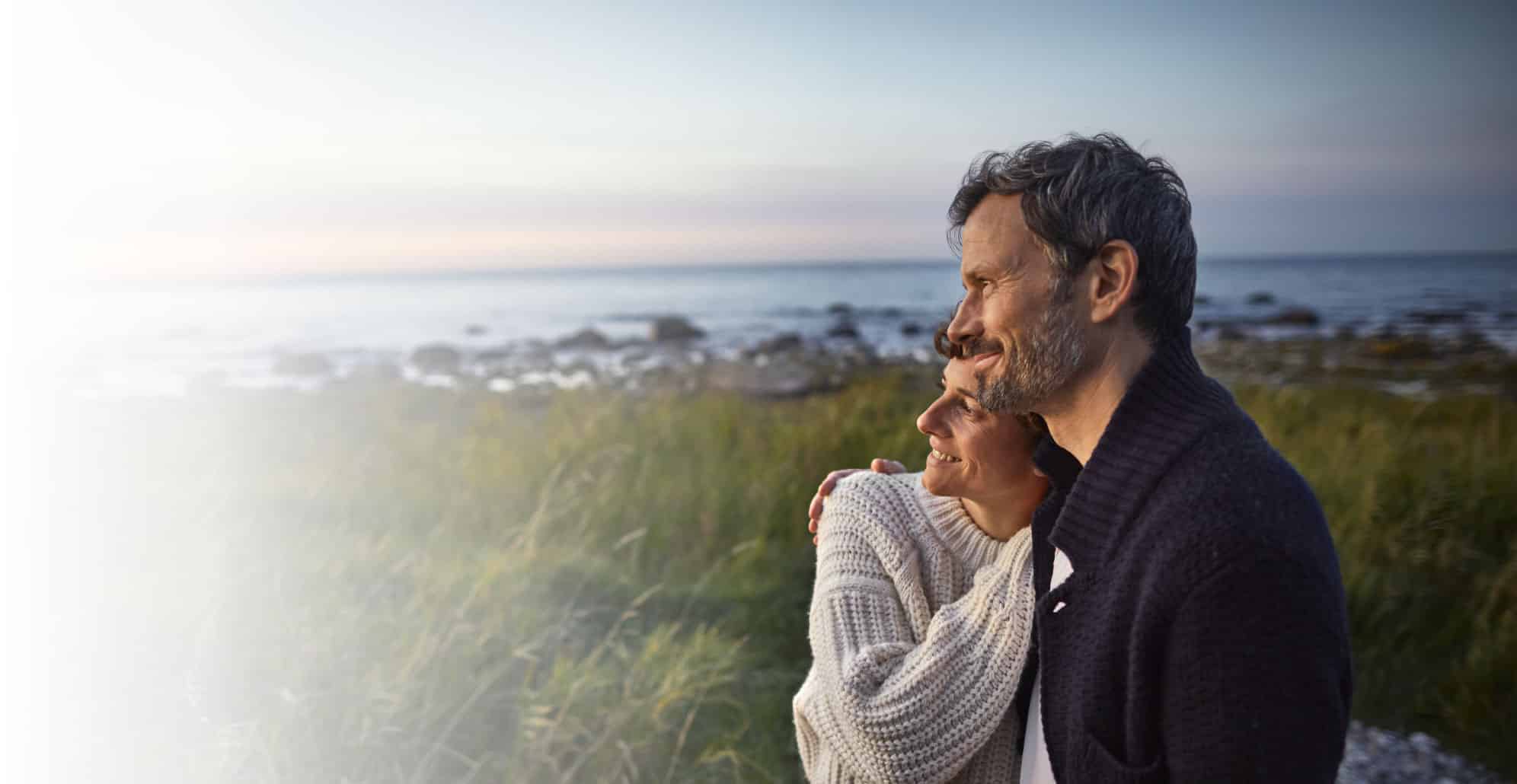 Couple hugging on a the beach looking into a brighter future.