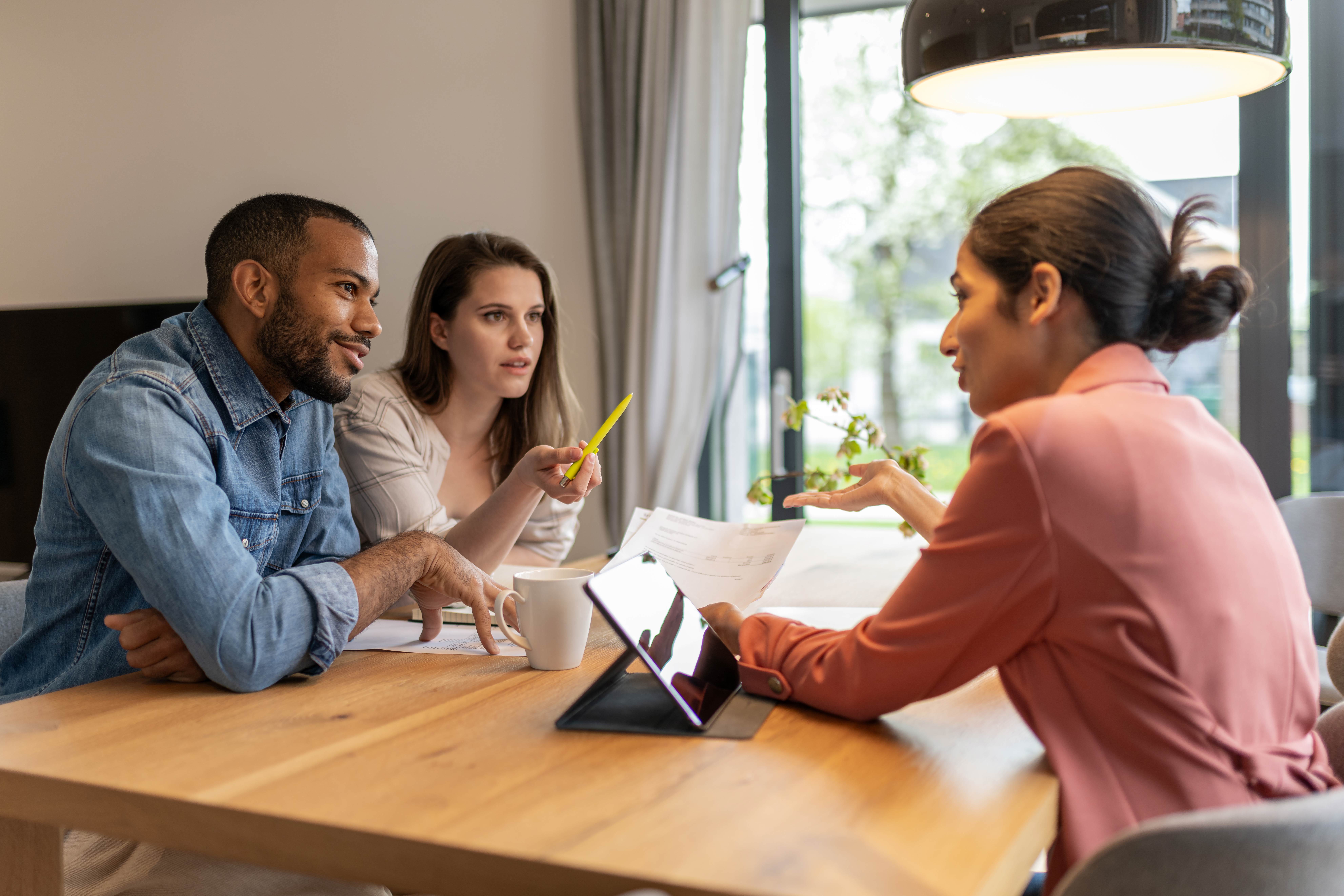 Young couple at table meeting with wealth advisor.