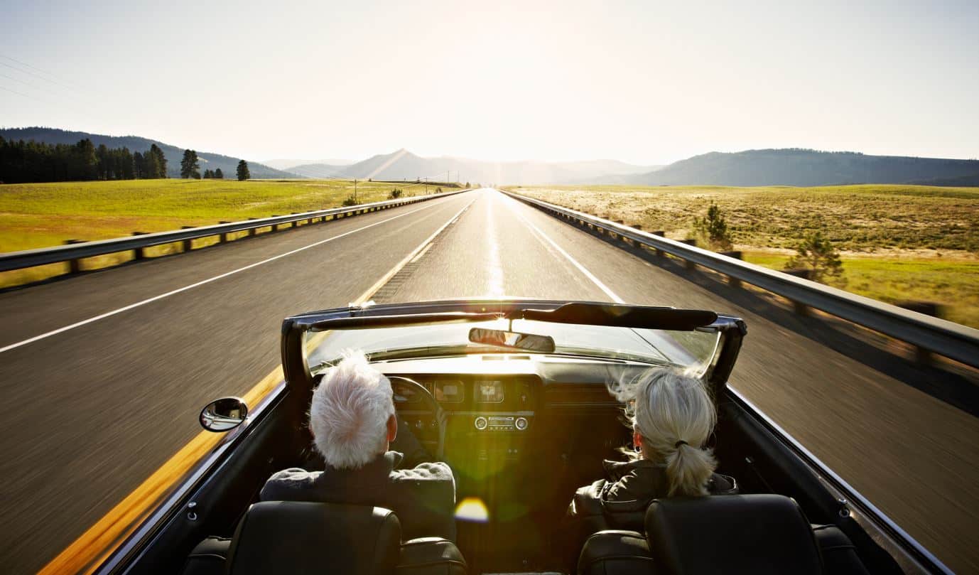 Retired couple driving away into the sunset