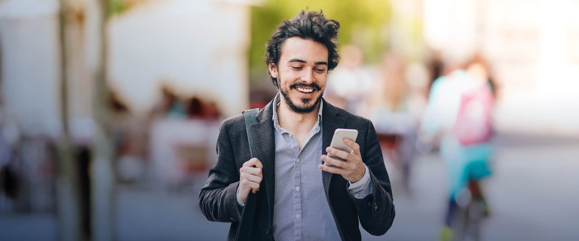 Young man smiling looking at his phone.
