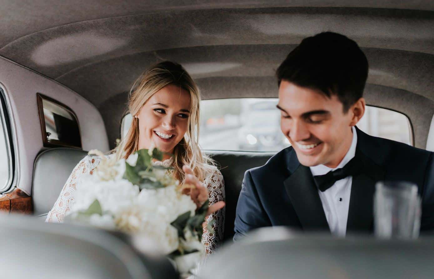 Couple being driven after wedding