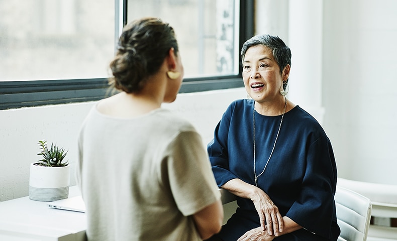 Smiling senior businesswoman in discussion with client in office conference room