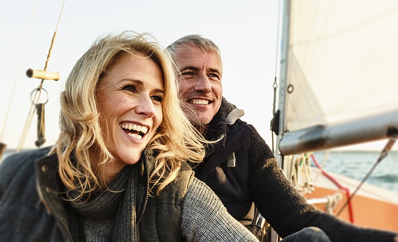 Mature couple on sailing boat, smiling